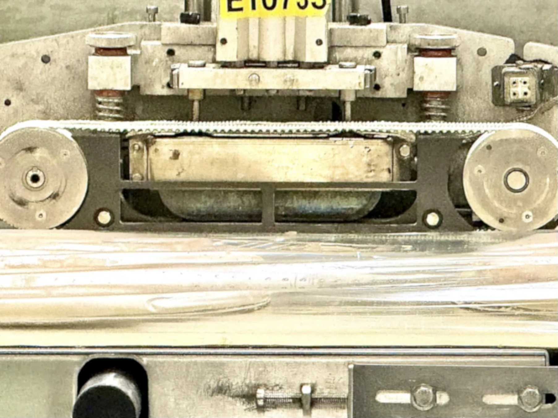 Heated sealing head on a frozen pizza flow wrapper with seal blade installed